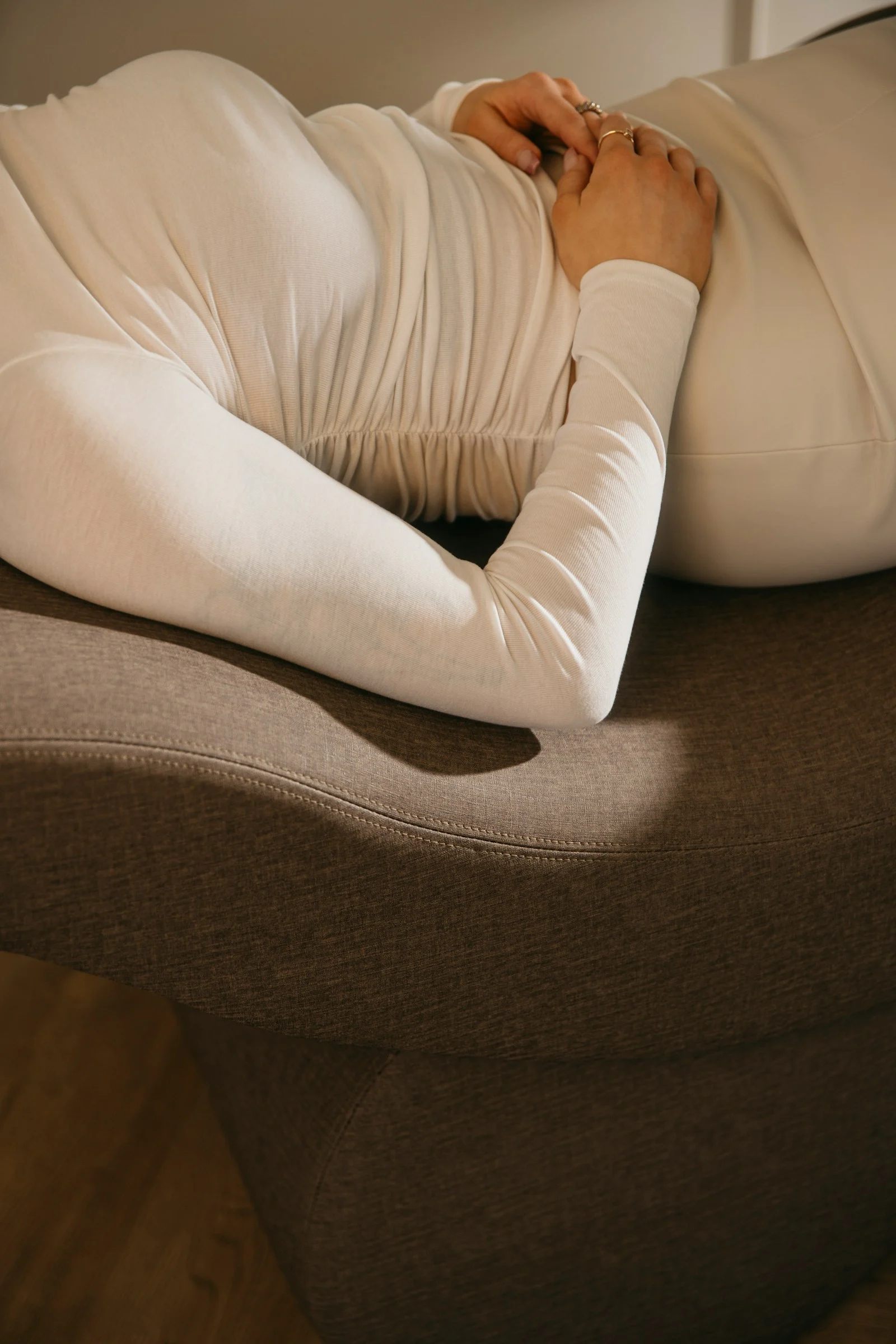 a woman laying on top of a brown couch